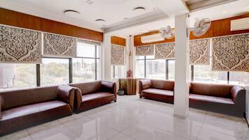 Una habitación amplia con dos sofás de cuero, ventanas grandes y paneles decorativos en las paredes.