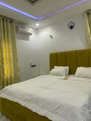 Une chambre d’hôtel équipée d’un lit, d’un appareil de climatisation et d’un panneau de commande fixé au mur.