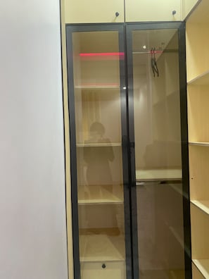 A room with a glass-fronted cabinet with multiple shelves. - 4-bedroom apartment in charming Akure with AC comfort (Akure)