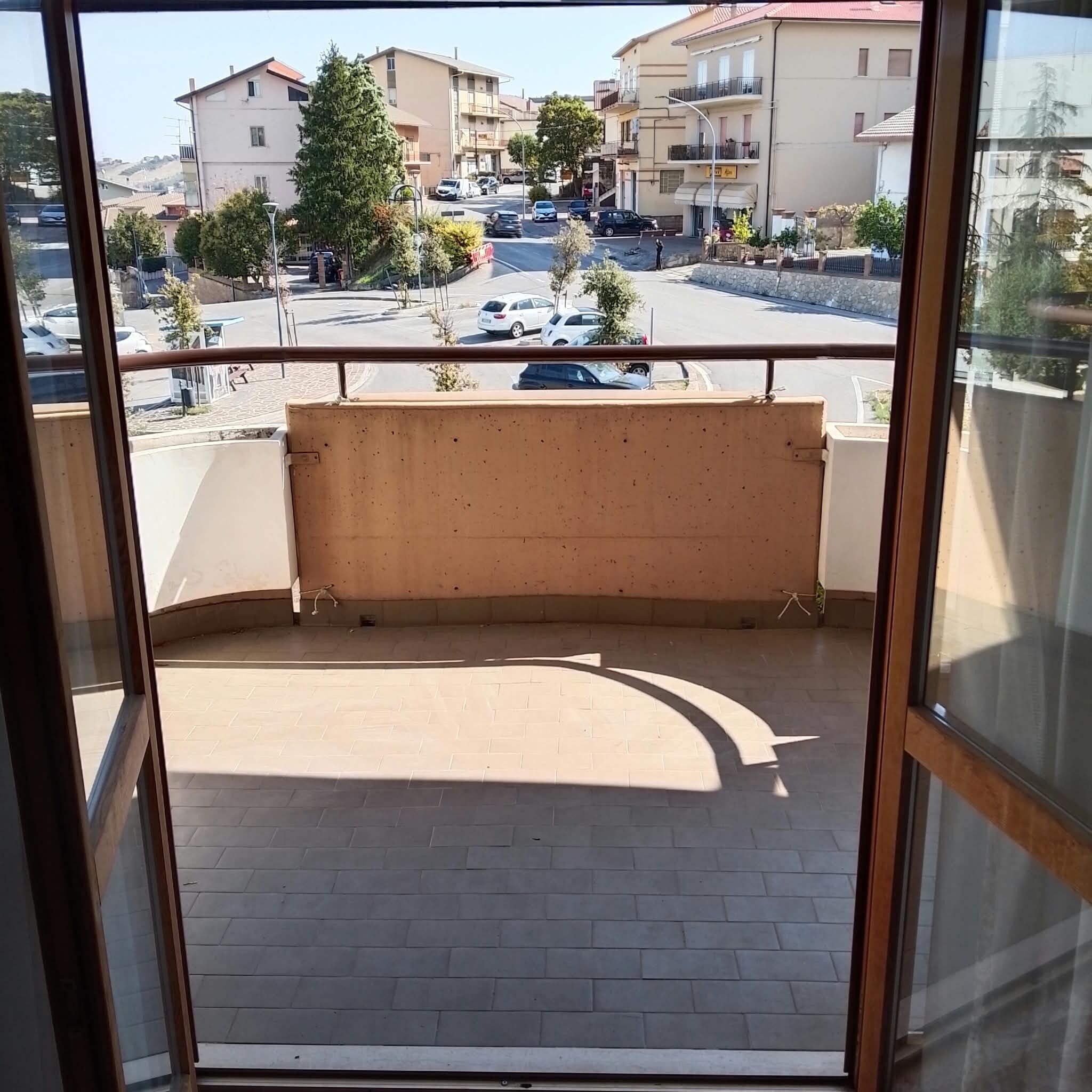 Ein Balkon mit Blick auf eine Straße und Gebäude.