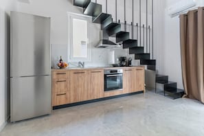 A modern kitchen with a built-in oven, a refrigerator, and a wooden countertop. - Deppie First Floor - Miralis Apartments (Episkopos)