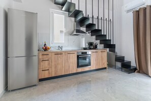 Eine moderne Küche mit Einbauofen, Kühlschrank und einer Holzarbeitsplatte.
