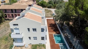 A multi-story residential building with a rooftop terrace, a swimming pool, and a small garden area. - Nicolas First Floor - Miralis Apartments (Episkopos)