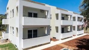 A modern multi-story residential building with balconies, a flat roof, and a clear sky. - Deppie Ground Floor - Miralis Apartments (Episkopos)