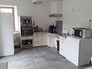 A modern kitchen with white cabinetry, a built-in oven, a microwave, and a sink.
