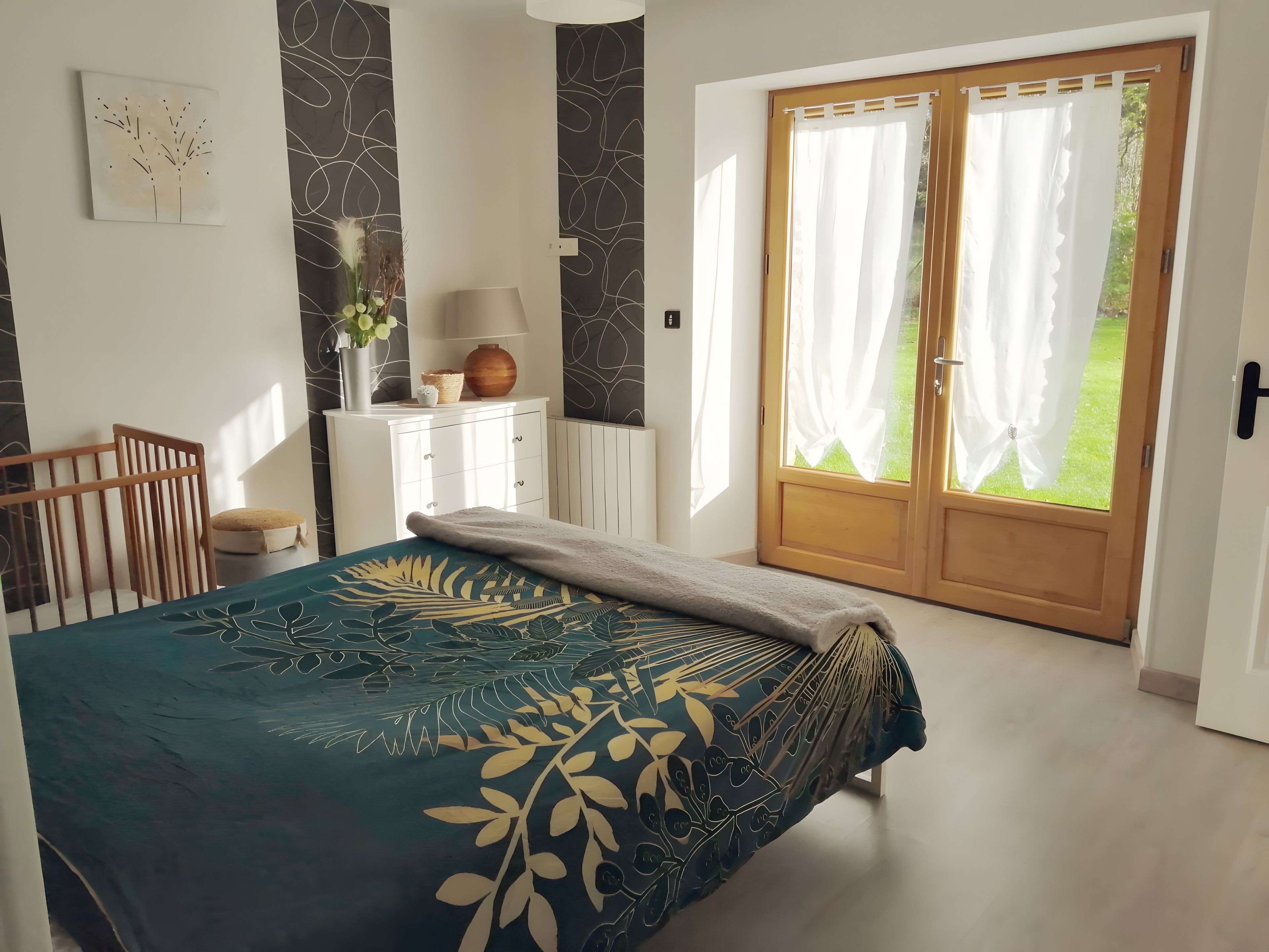 Ein Schlafzimmer mit Bett, Schminktisch, Lampe und Blick ins Freie.