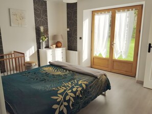Una camera da letto con un letto, una cassettiera, una lampada e vista sull'esterno.