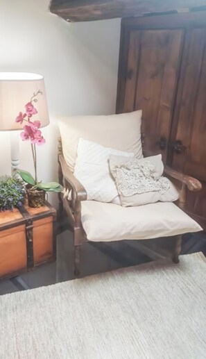 A cozy room with a wooden chair, a small table with a lamp, and a potted plant. - Il Grillo (Rosignano Marittimo)