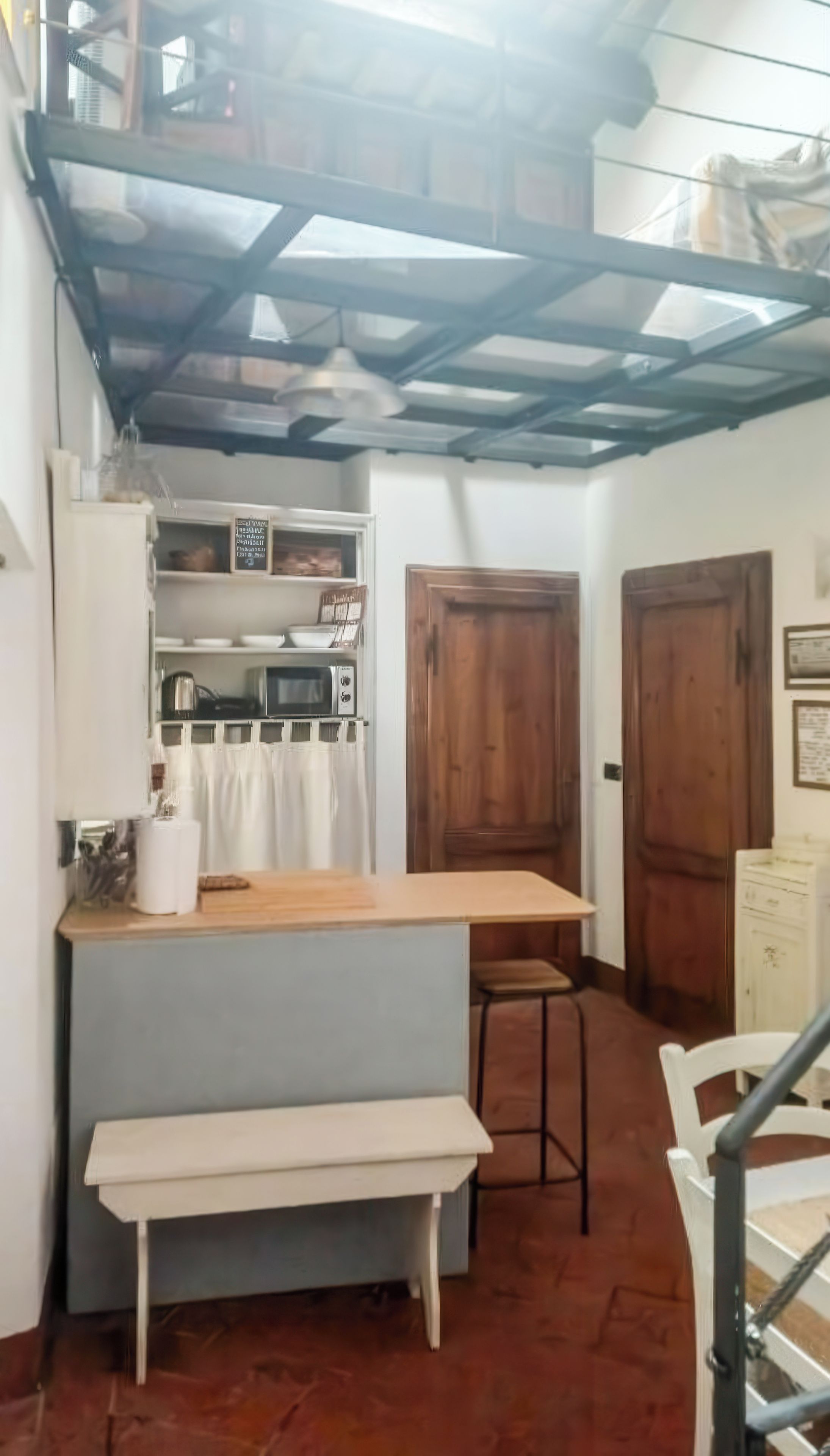 Une cuisine compacte avec un comptoir en bois, un banc et un coin repas.