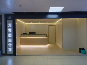 Een receptie met een balie, een wandbord en een deur.