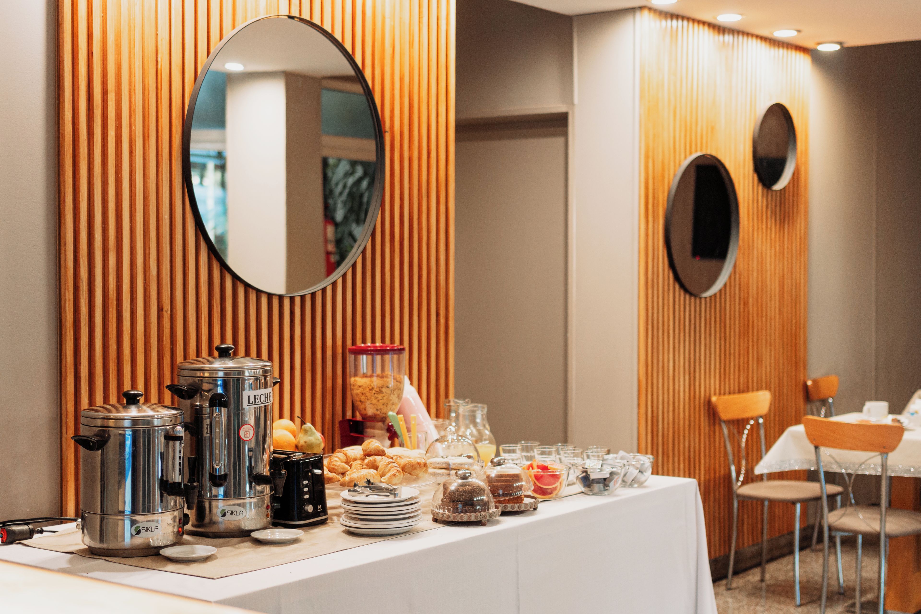 Un buffet proposant une variété de plats, un coin café et un miroir accroché au mur.