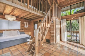 A wooden interior with a staircase, a sofa, and a view through large windows. - Private Island Oasis | Pool + Dock • Boat-In Only (Longboat Key)