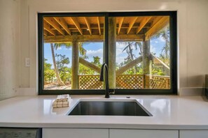 A kitchen with a large window, a sink, and a towel rack. - Private Island Oasis | Pool + Dock • Boat-In Only (Longboat Key)