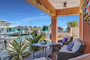 A covered outdoor seating area with a view of a marina and boats. - Coral Tides - Waterfront Escape with 40' Dock (Marathon)