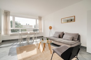 Ein modernes Wohnzimmer mit einer Couch, einem Couchtisch und einem Sessel.