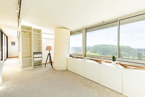 Ein geräumiger Raum mit großem Fenster, Einbauschrank und Lampe.