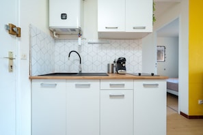 A compact kitchen with a sink, a Bosch coffee maker, and a white Bosch water heater. - Le Cocon du Cap d'Agde - 5 min du port (Agde)