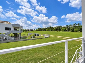 A modern building with a flat roof, a grassy field, and a clear sky. - Brand-New Modern 2BR Apt at San Ignacio, Belize (San Ignacio)