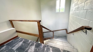 Eine Holztreppe mit Marmorboden, die zu einer Zwischenebene führt.