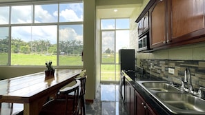 A kitchen with a large window, a wooden table, and a sink. - New 2BR - 2BA Apartment at San Ignacio, Cayo (San Ignacio)