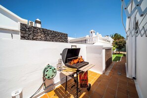 A barbecue grill with a stone wall and a white fence in the background. - Blue Beach - Three Bedroom Villa, Sleeps 6 (Tías)