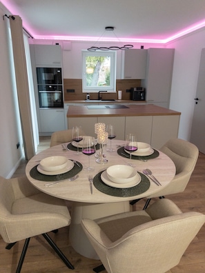 A dining area with a round table set for four, surrounded by four chairs.