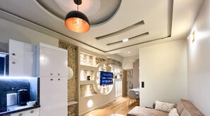 A modern living room with a flat-screen TV, a sofa, and a coffee table. - UrbanFlat 196  -  Prestige Apartment Saint Honoré (Paris)
