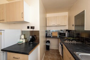 A compact kitchen with a refrigerator, coffee maker, toaster, microwave, and stove. - Toast Stays - The Barden Residence (Darlington)