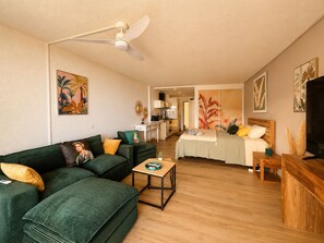 A modern living room with a green sofa, a wooden coffee table, and a ceiling fan. - New Listing (Saint-Martin)