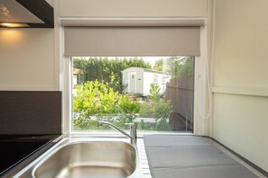 Eine Küche mit Spüle und Fenster mit Blick auf einen Garten.