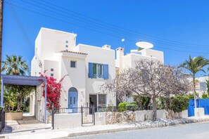 A white building with blue shutters, a gated entrance, and a clear blue sky. - Villa Lilly Rose - Three Bedroom Villa, Sleeps 6 (Polis)