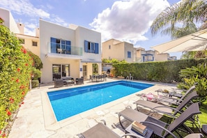 A modern poolside area with a rectangular pool, outdoor furniture, and a two-story building with balconies. - Villa Lilly Rose - Three Bedroom Villa, Sleeps 6 (Polis)