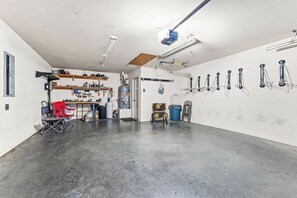 A garage with a workbench, shelves, and various tools. - Riders Ready! Pet Friendly Downtown Bentonville/Momentary Location (Bentonville)
