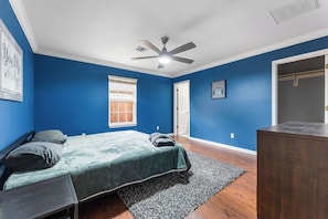 A bedroom with a bed, a ceiling fan, a window, and a door. - Riders Ready! Pet Friendly Downtown Bentonville/Momentary Location (Bentonville)