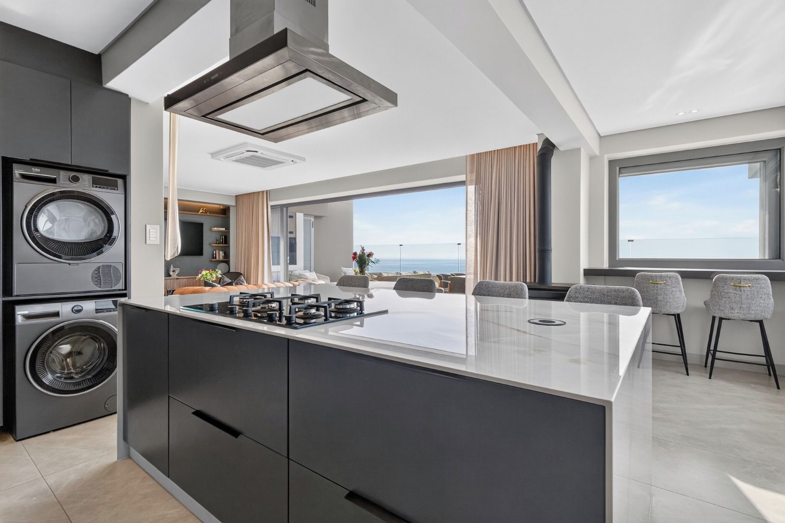A modern kitchen with a central island, built-in appliances, and a view to the outdoors.