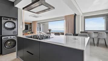 A modern kitchen with a central island, built-in appliances, and a view to the outdoors.