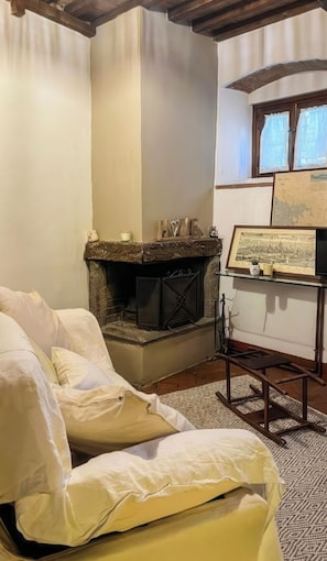 A room with a fireplace, a bed, and a framed picture on the wall. - La Cicala (Rosignano Marittimo)