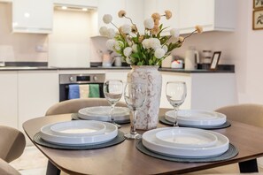A dining table set with plates, glasses, and a vase with flowers. - Toast Stays - The Bluebell at Parsons House (Washington)