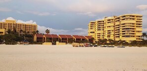 A beachfront hotel with multiple buildings, a sandy beach, and a clear sky. - 2-bedroom condo in serene Marco Island right on the beach (Marco Island)