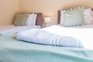A hotel room with two beds, each with a pillow and a lamp between them. - Toast Stays - Church Street (Hill Top)