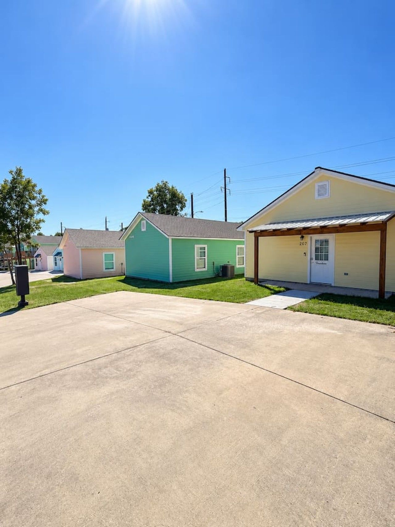 A residential street with houses, a clear sky, and a sunny day.