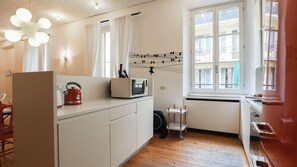 A modern kitchen with a microwave, kettle, and a window with a view of the building. - Italianway Comfort - Agudio 8 (Milano)