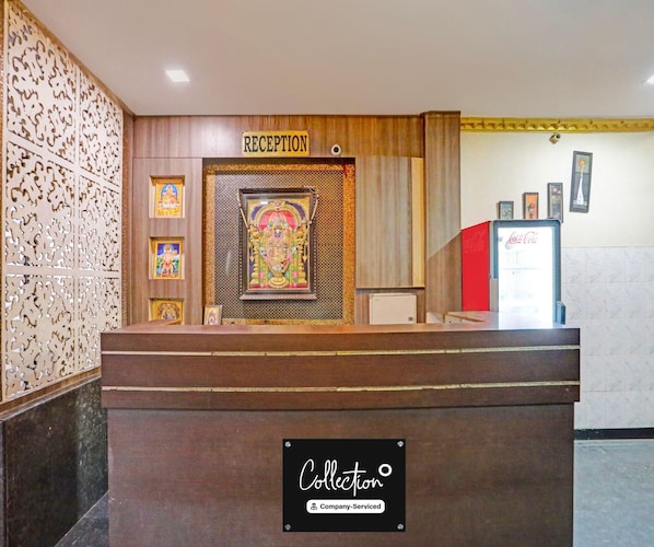 A reception desk with a 'RECEPTION' sign, framed religious artwork, and a 'Collection' sign indicating company service.