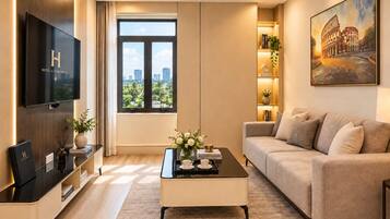 A modern living room with a flat-screen TV, a sofa, a coffee table, and a bookshelf.