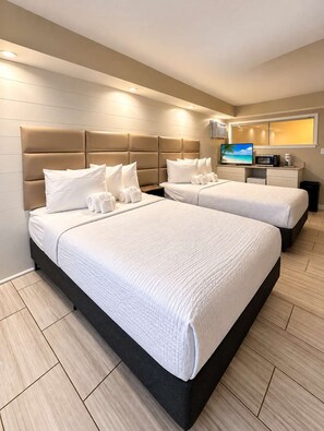 A hotel room with two beds, a flat-screen TV, a coffee machine, and a view of the beach. - Myrtle Beach Getaway | Unit 227 (Myrtle Beach)