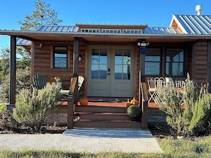 A log cabin with a front porch, two chairs, a small table, and a potted plant. - 34 acre Retreat Mountain View hiking trails King 1bedroom 23 mins to Cleveland (Calhoun)