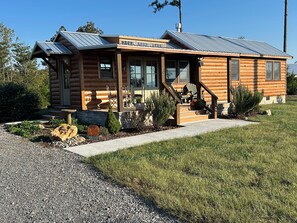 A log cabin with a porch, outdoor seating, and a welcome sign. - 34 acre Retreat Mountain View hiking trails King 1bedroom 23 mins to Cleveland (Calhoun)