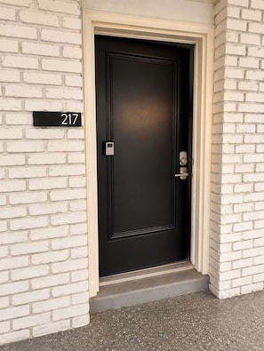 A black door with a number plate indicating the address 217. - The Coastal Pearl at 300 Tenth | 217 (Myrtle Beach)