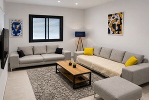 A modern living room with two sofas, a coffee table, and a floor lamp. - Peaceful Garden (Tunis)