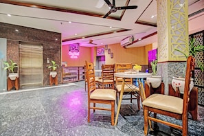 A hotel lobby with a reception desk, a bar area, and seating arrangements. - Townhouse by OYO Eastern View (Zirakpur)